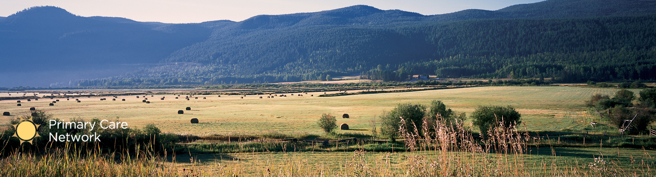 100 Mile House grass field with hills in the background